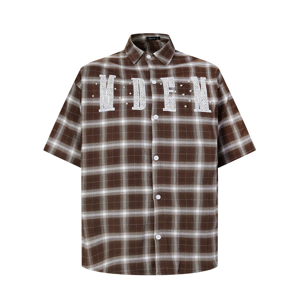 Oversized plaid short-sleeve shirt with embroidered letter patch and pearl studs in brown colorway, front view