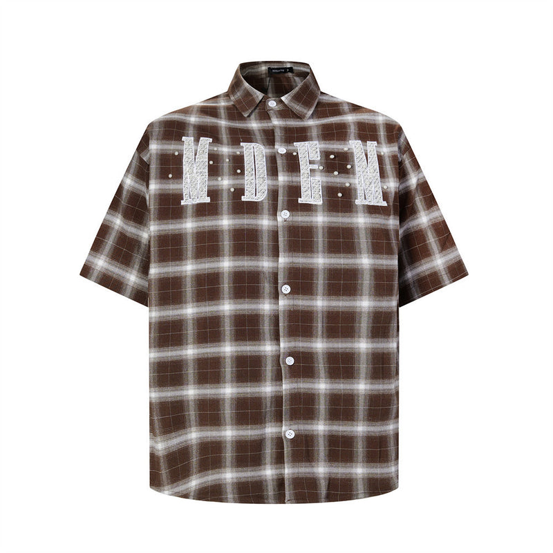 Oversized plaid short-sleeve shirt with embroidered letter patch and pearl studs in brown colorway, front view
