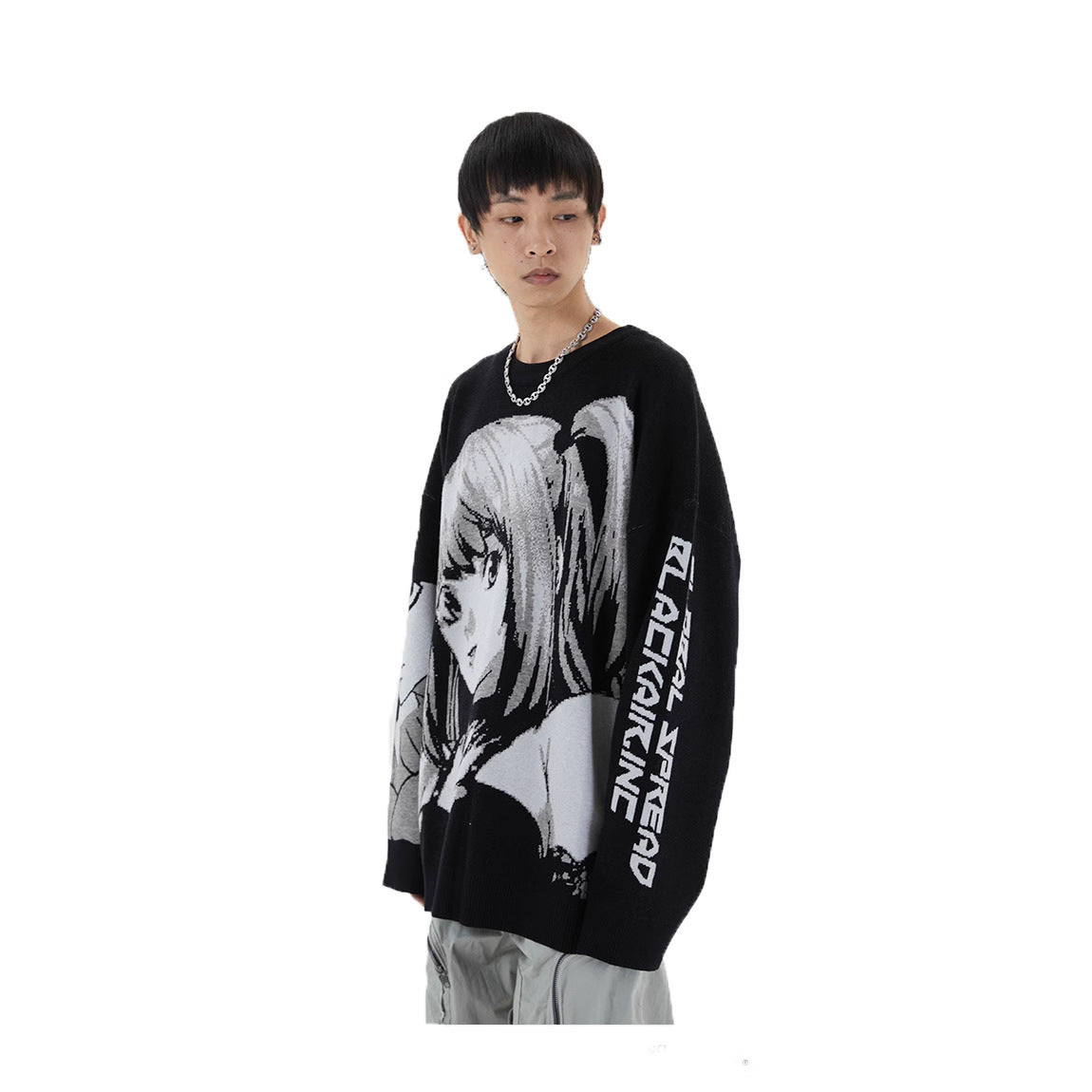 A person with short, dark hair and a necklace models gothic streetwear by wearing the Death Note Premium Knit Sweater, featuring a Misa Amane monochrome jacquard design, against a plain white background.