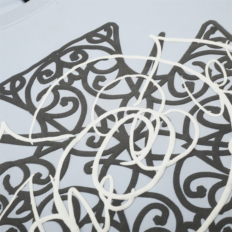 Close-up of black and white Celtic cross graphic print on light blue tee