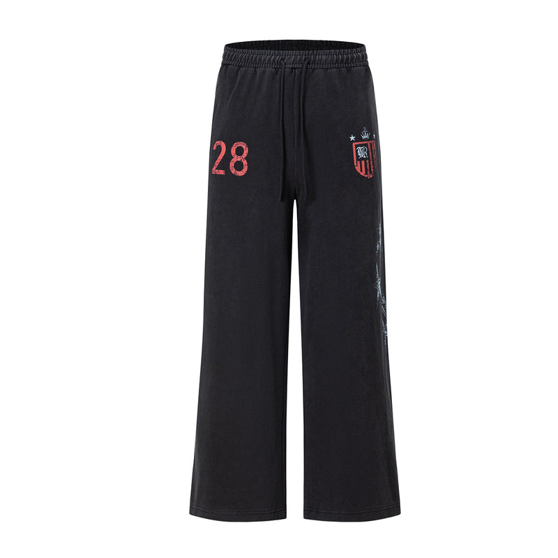 Pantalon de survêtement noir à jambe large avec numéro 28 rouge effet usé, écusson varsity et motif étoile sur l’extérieur de la jambe