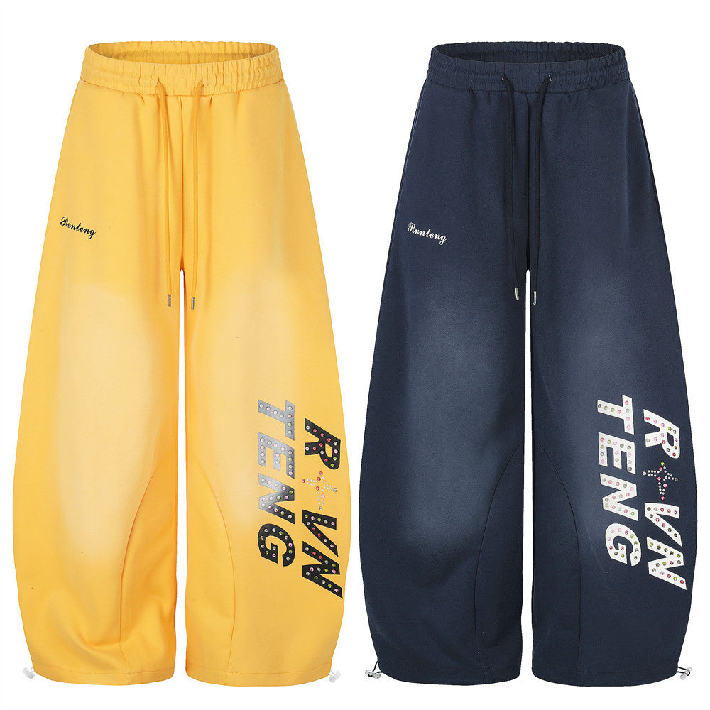 Wide leg sweatpants in yellow and navy with rhinestone letter print, front view