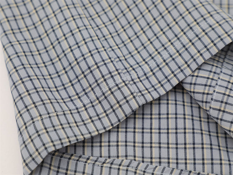 Close-up of gray plaid shirt sleeve folded over the body of the shirt