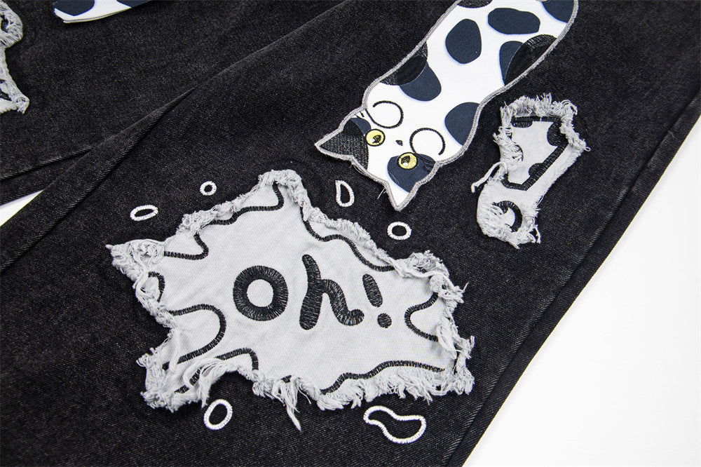 Jean noir large avec patchs chat cartoon et finitions contrastantes imprimées dalmatien