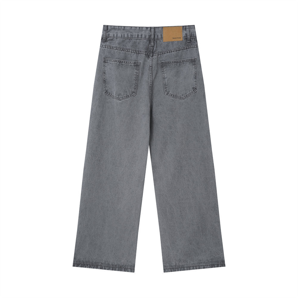 Back view of washed grey baggy jeans with patch pockets and tan waistband label