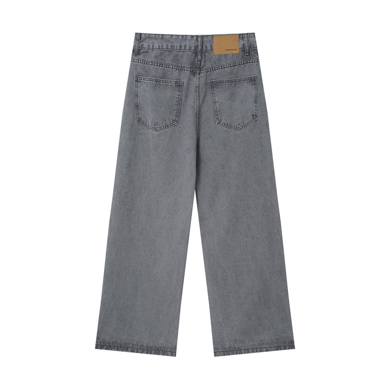 Back view of washed grey baggy jeans with patch pockets and tan waistband label