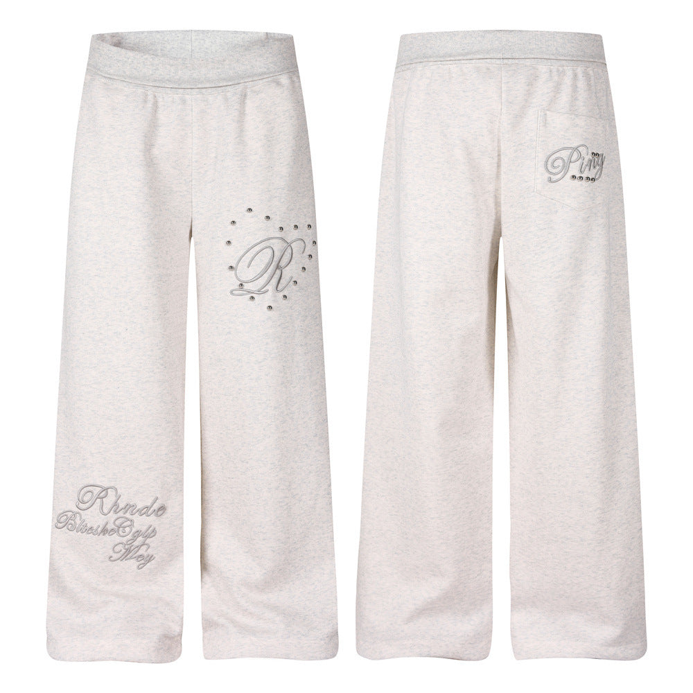 Jogging homme gris chiné à jambes larges, avec broderie script R en 3D et clous bombés argentés sur la cuisse gauche, vues de face et de dos