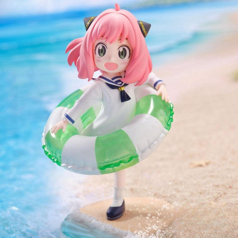 A dream for anime figure collectors, the Anya Forger Swimming Figure by Spy × Family is a 10cm PVC collectible featuring Anya with pink hair and cat ears in a sailor-style dress, holding a green and white inflatable ring as if strolling by the water on a sunny beach.