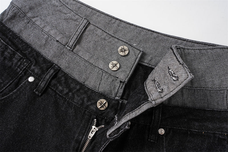 Close-up of layered black and gray waistband with metal buttons and zipper fly