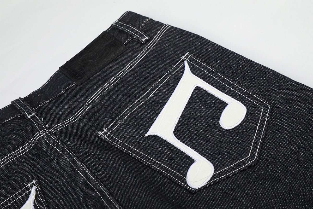 Jean baggy à jambes larges avec broderies et patch en cuir motif notes de musique — Denim noir brut