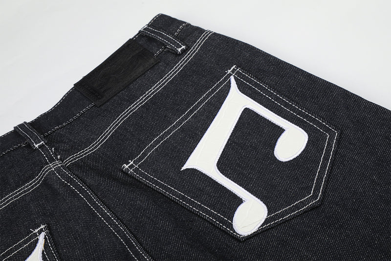 Jean baggy à jambes larges avec broderies et patch en cuir motif notes de musique — Denim noir brut