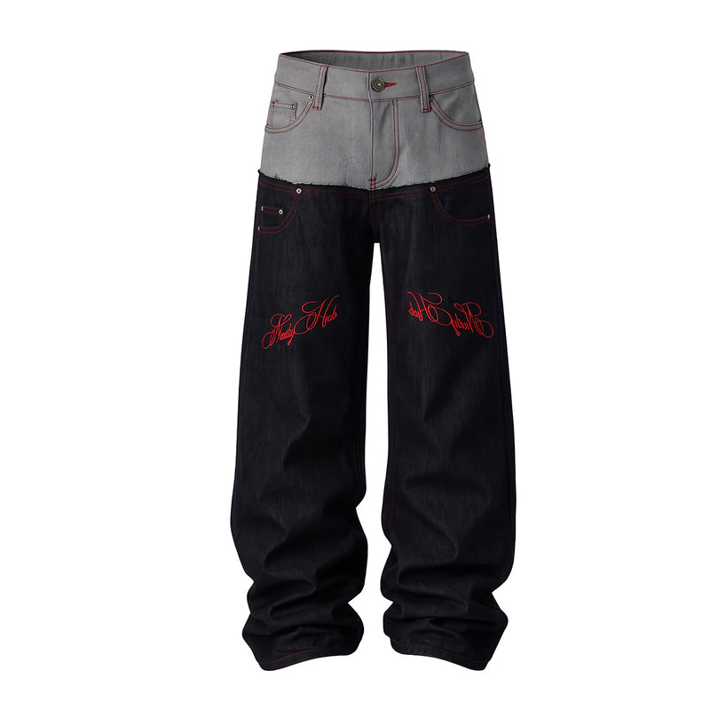 Jean wide-leg en denim brut gris et noir bicolore, avec broderie rouge façon écriture sur les cuisses et l’empiècement dos, vue de face et de dos