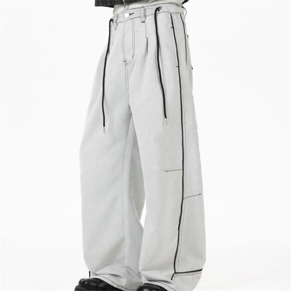 Men's wide-leg deconstructed jeans in off-white washed denim with black contrast topstitching and drawstring waist