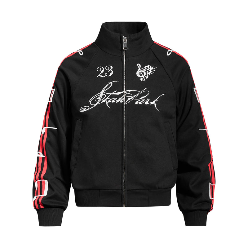 Black full-zip stand collar track jacket with Skate Park script, number 23, music note graphic, and red contrast sleeve strip
