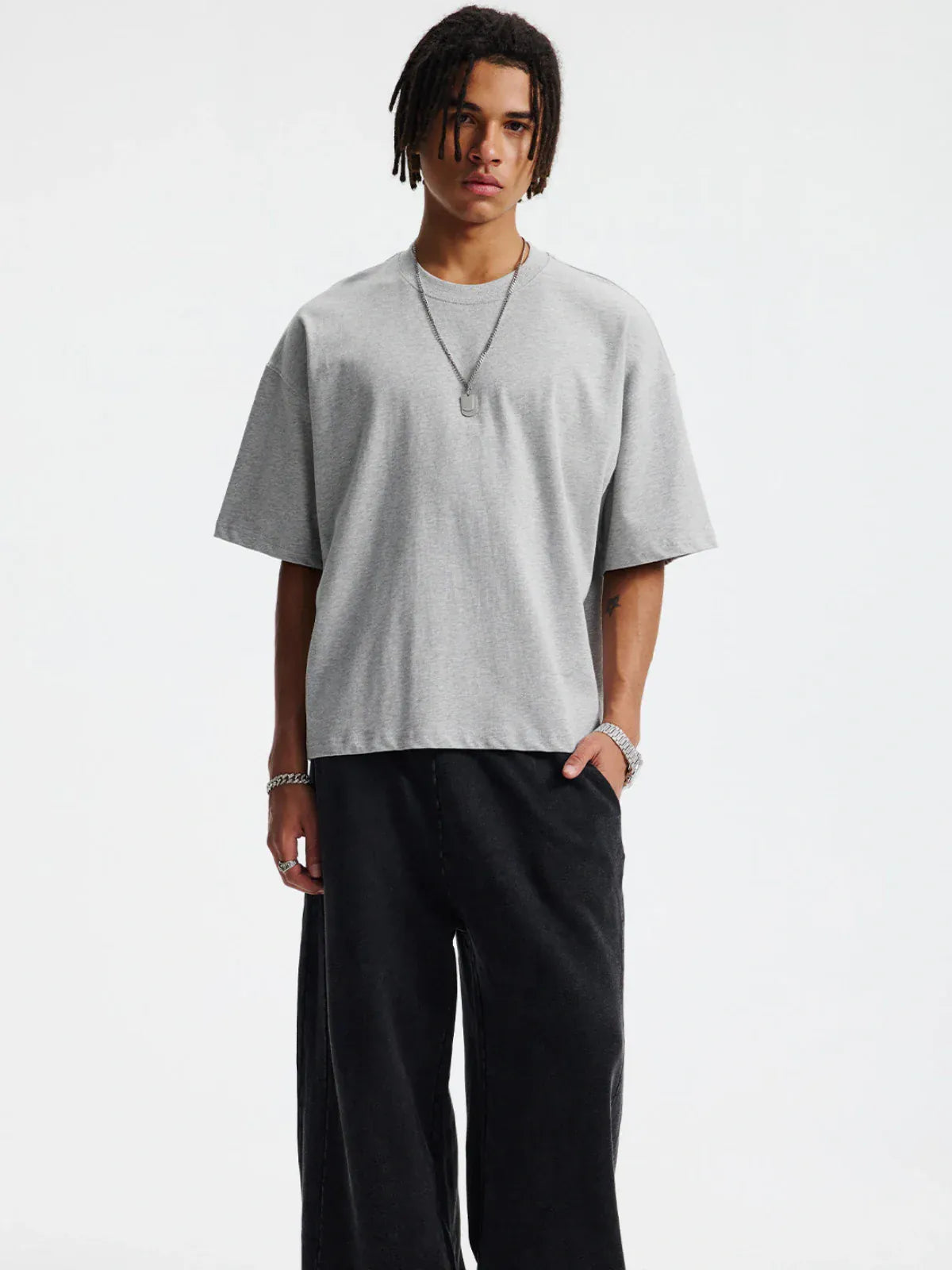 A person wears the Custom Anime Character Heather Gray T-Shirt (230GSM 100% cotton), paired with black wide-leg pants and silver jewelry, standing against a white background for a playful, anime-inspired modern look.