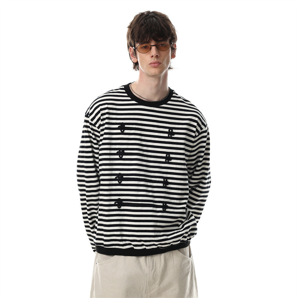 Long sleeve black and white striped shirt with 3D floral knit appliqués and contrast ribbed crew neck, worn by male model