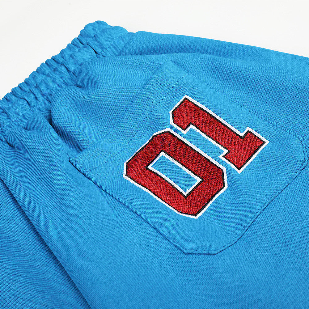 Close-up of back pocket patch with red 01 on blue sweatpants