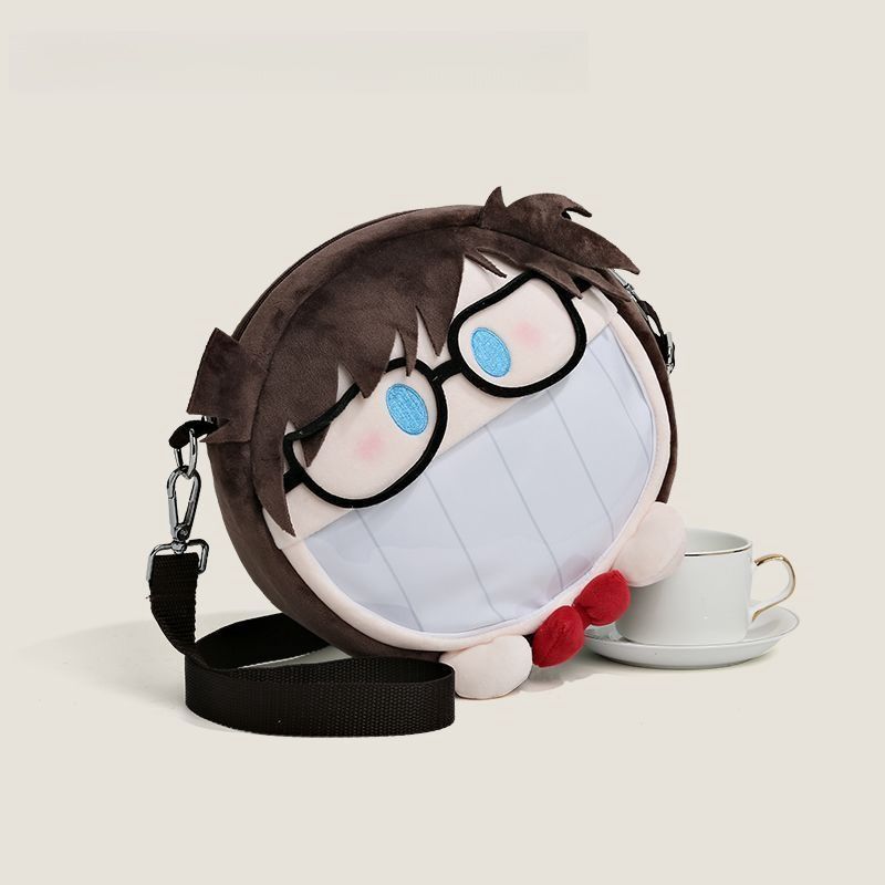The Seakoff Detective Conan Edogawa Conan plush shoulder bag features a charming face with glasses, mask, hair details, a black strap, and red bowtie, capturing Conan's iconic look. It includes a transparent mouth pocket and is accompanied by an elegant white teacup and saucer.