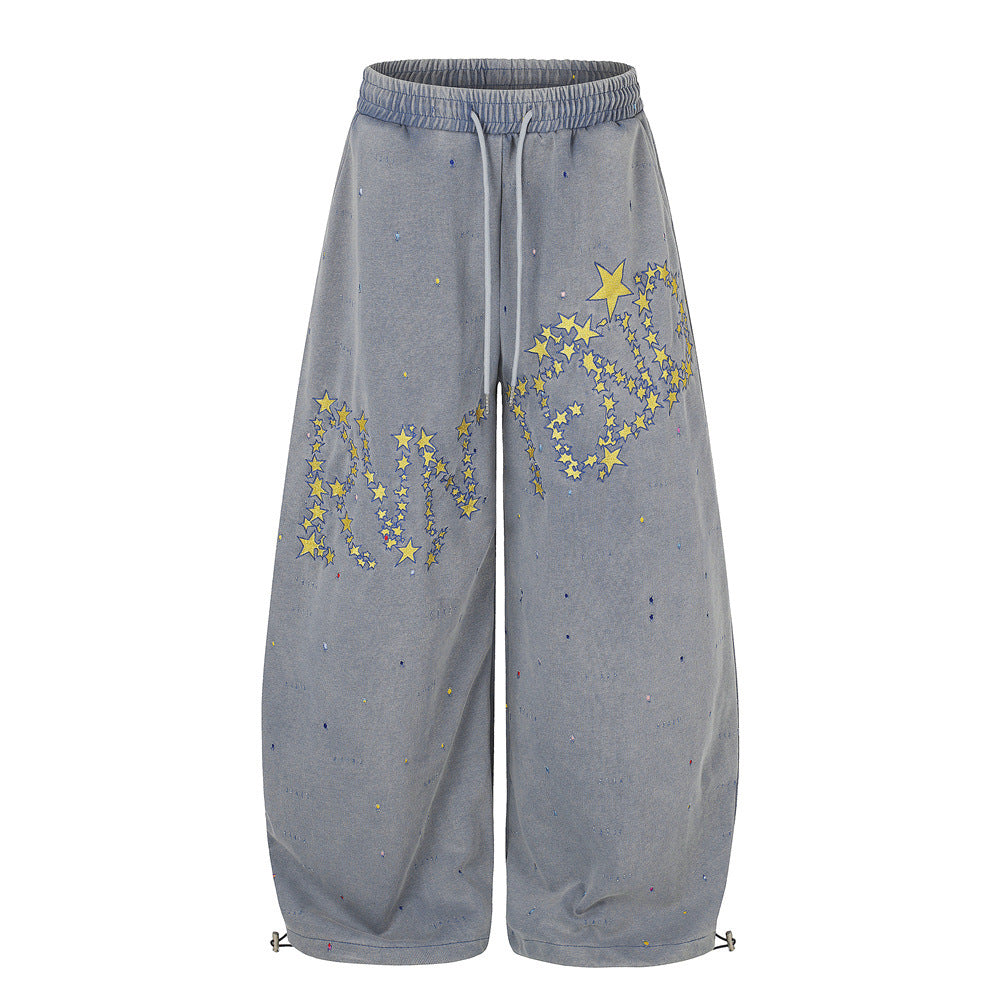 Pantalones de chándal de pierna ancha con efecto lavado ácido, bordado de estrella amarilla y salpicaduras de pintura, en azul grisáceo