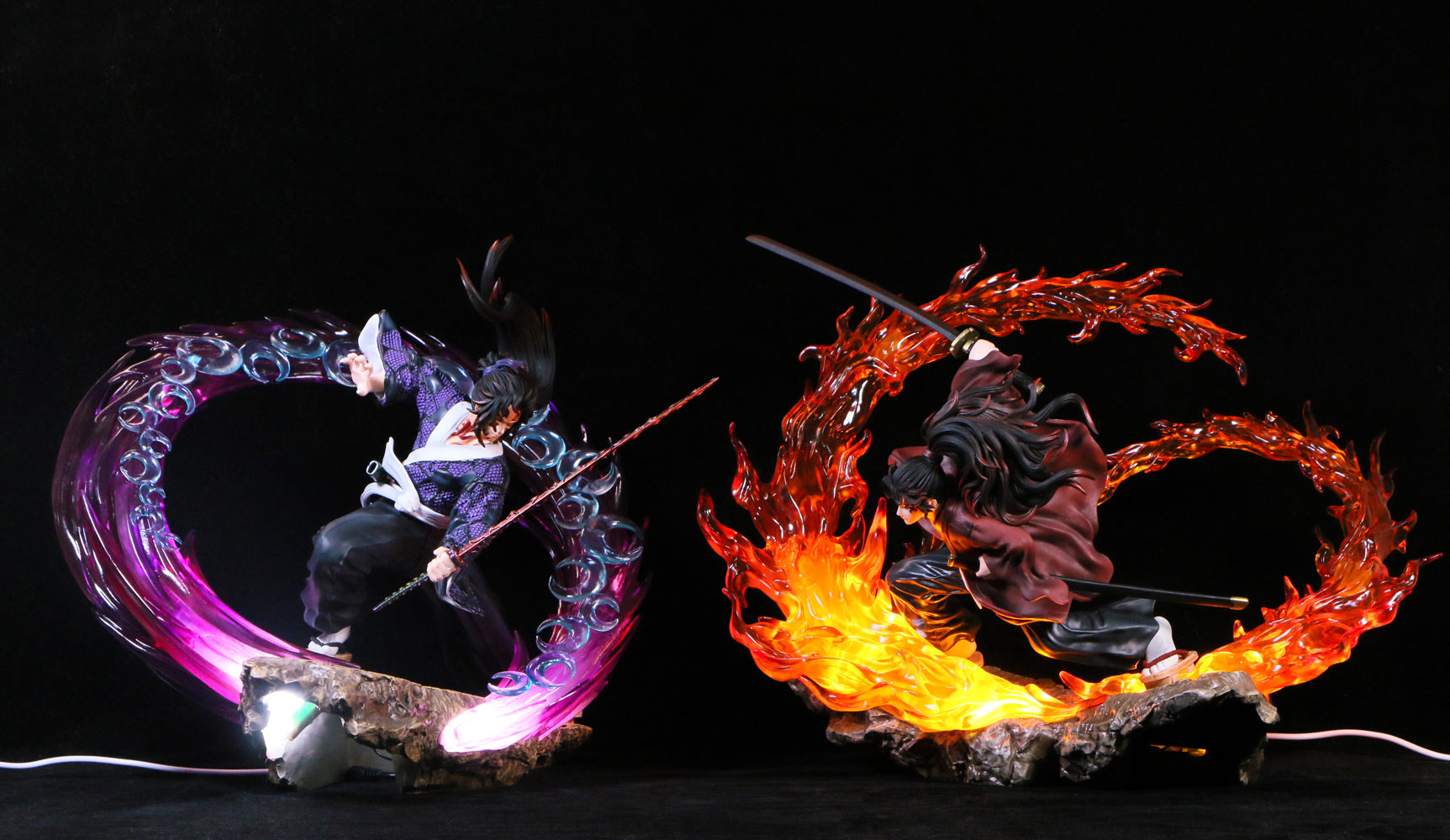 The Kokushibo Demon Slayer Figure, a premium 30cm PVC statue, features him in an action pose with glowing purple water-like swirls, while his companion showcases fiery red flames. Both stand on rocky bases against a black background.