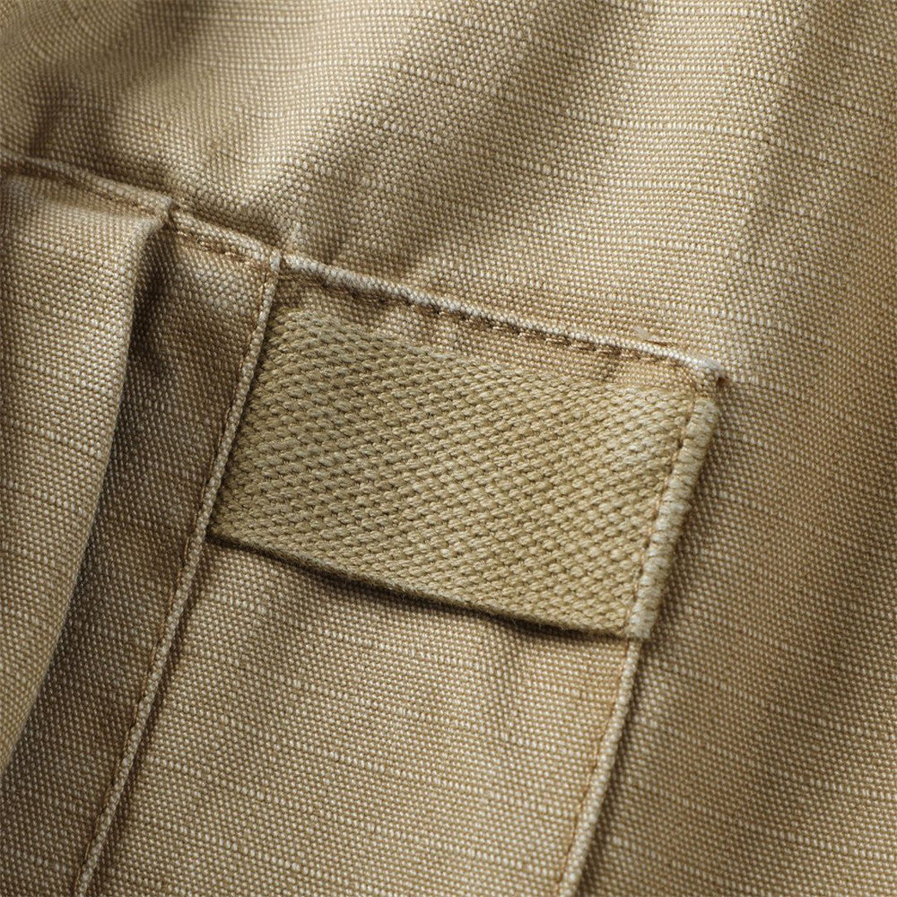 Close-up of khaki cargo shorts pocket flap with woven tab detail