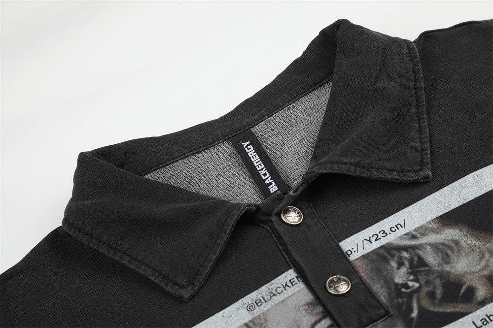 Close-up of black polo collar and button placket with printed graphic underneath