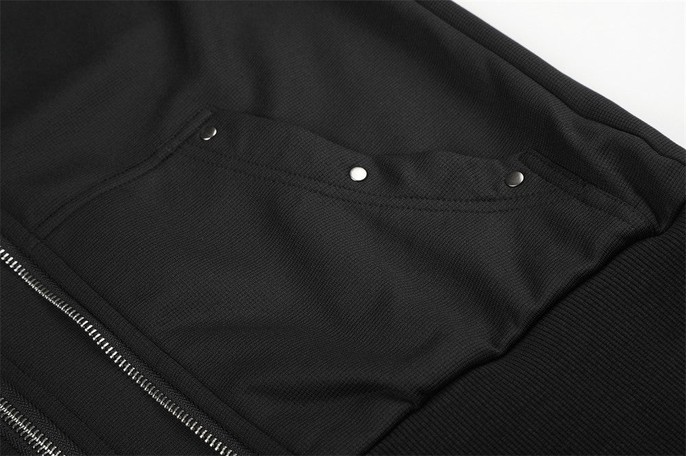 Close-up of black pocket flap with silver snap buttons on the jacket front