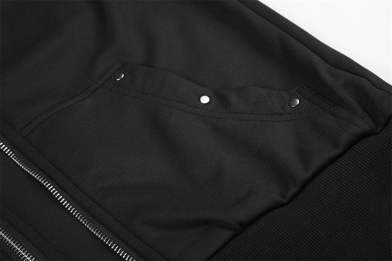 Close-up of black pocket flap with silver snap buttons on the jacket front