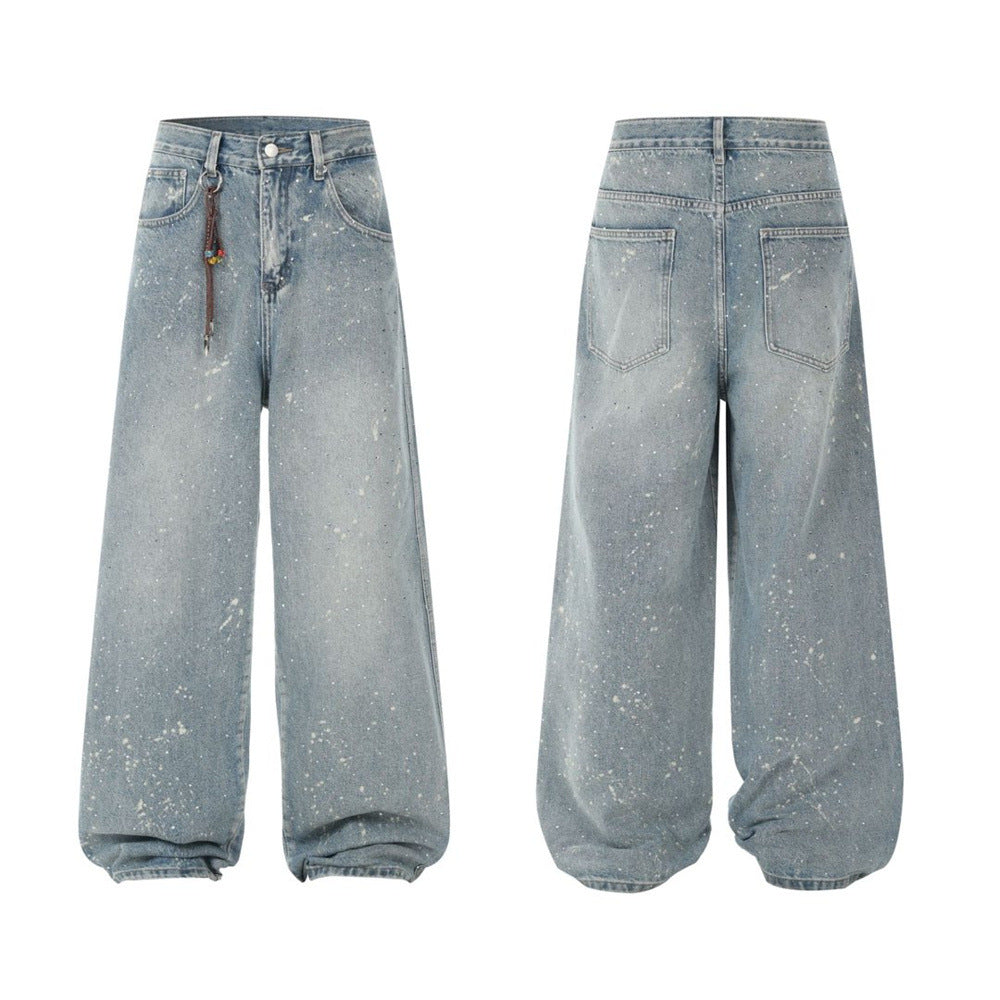 Men's wide-leg light blue washed denim jeans with paint-splatter print and rhinestone stud detailing, front and back view