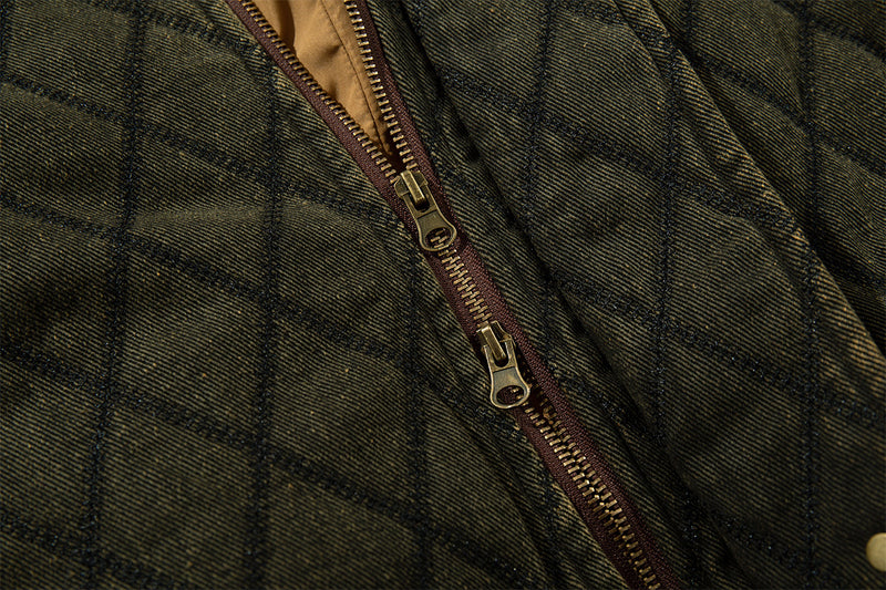 Close-up of the olive quilted jacket front zipper with a brown zipper tape and metal pull