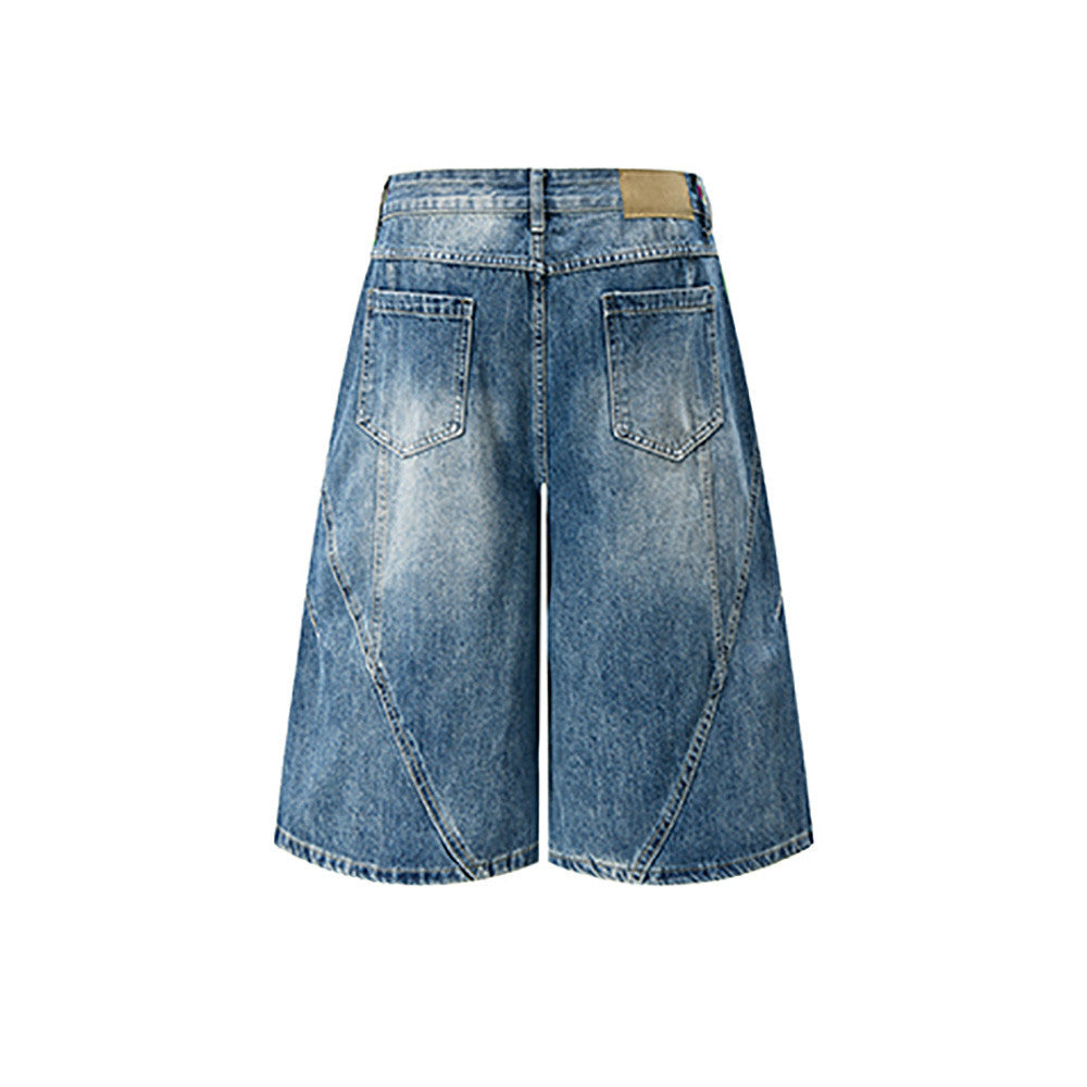 Back view of light blue distressed denim shorts with wide legs and patch detail at waistband