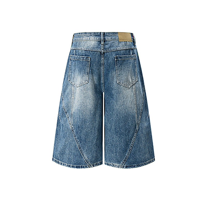 Back view of light blue distressed denim shorts with wide legs and patch detail at waistband