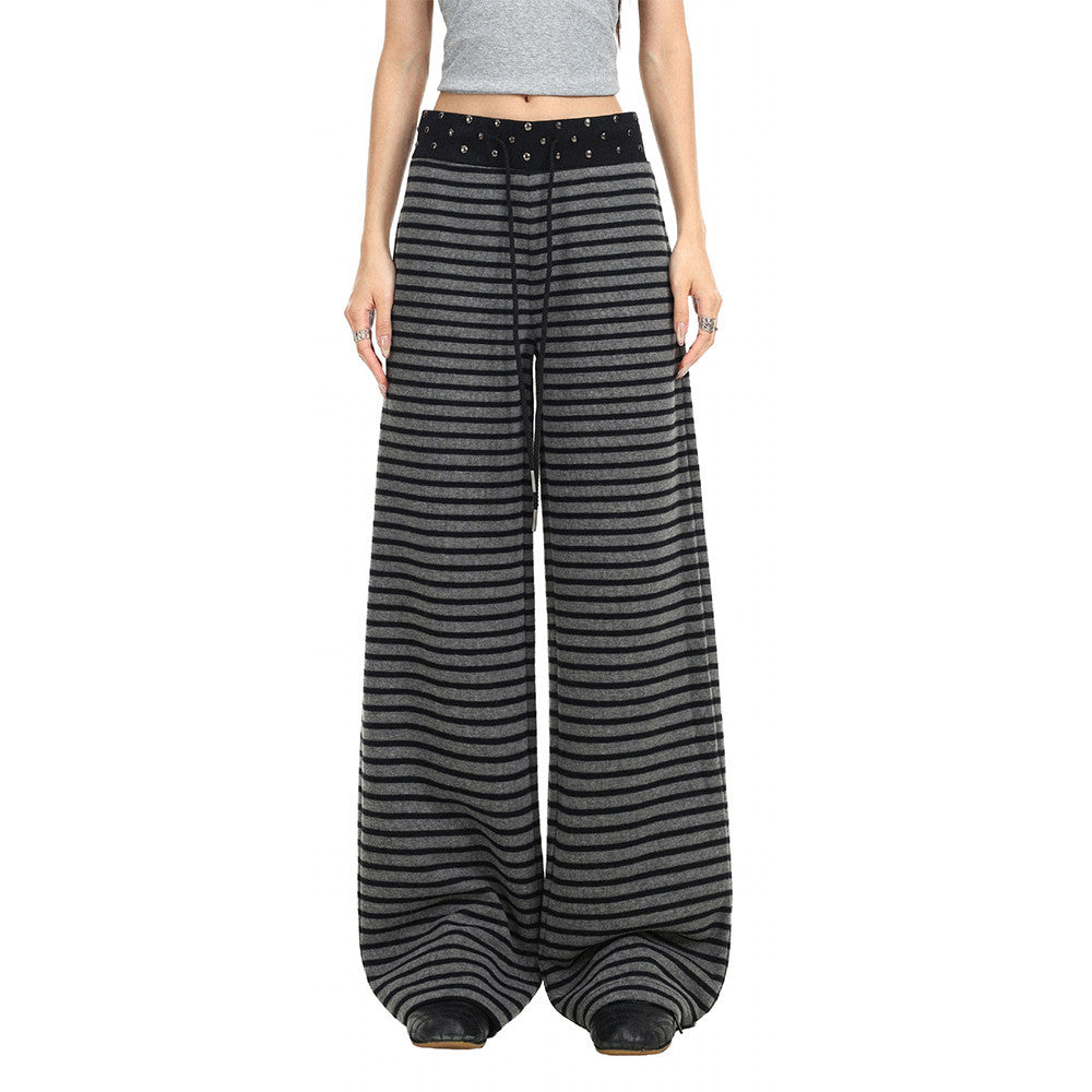 Model wearing black and gray striped wide-leg pants with studded waistband, front view