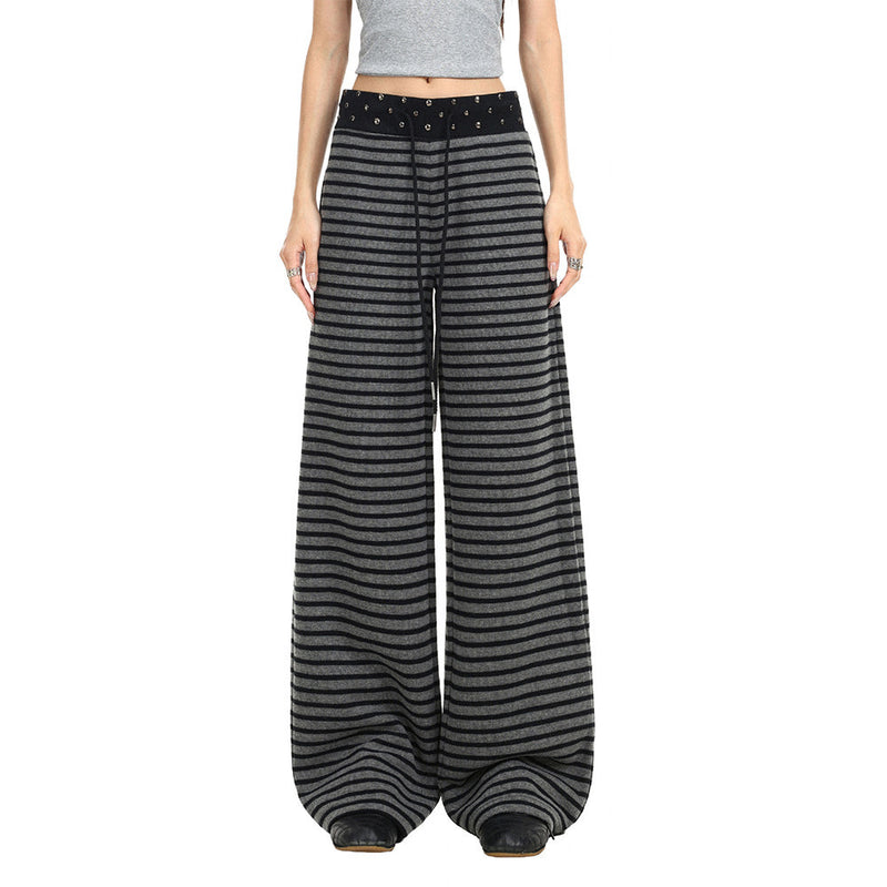 Model wearing black and gray striped wide-leg pants with studded waistband, front view