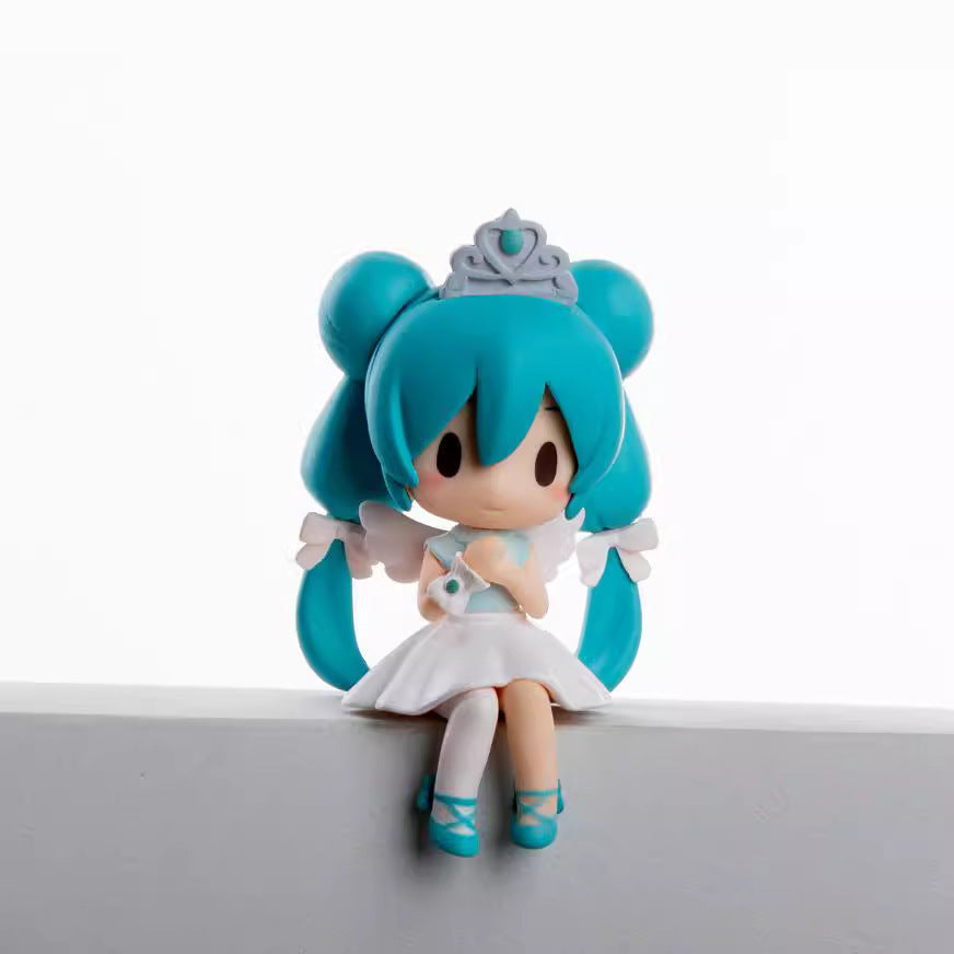 The Hatsune Miku Prayer Hugging Angel Princess 2-piece Set features a 7.5cm PVC figure with blue hair styled in buns, a tiara, white dress, and angel wings. The cartoon-like figurine sits on a white block against a plain background.