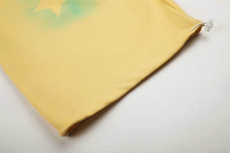 Close-up of yellow sweatpants leg hem with star print and clear cord stopper