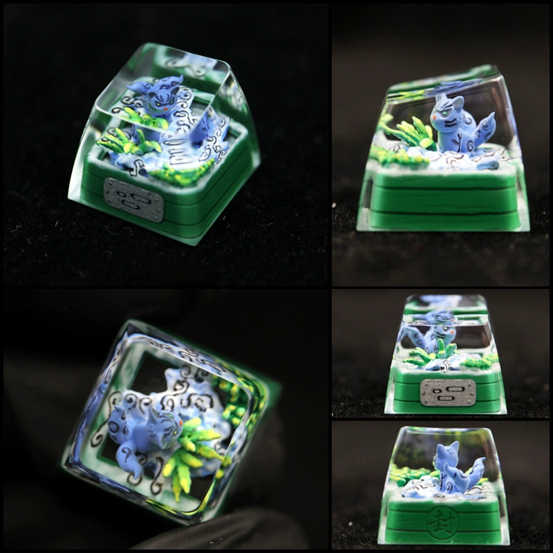 A transparent top keycap featuring a whimsical blue dragon on a green base, reminiscent of the Bijuu Collection. Multiple angles showcase its intricate design, perfect for any Tailed Beasts Naruto Keycaps ensemble by Naruto, including Kurama, Shukaku, and Saiken designs.