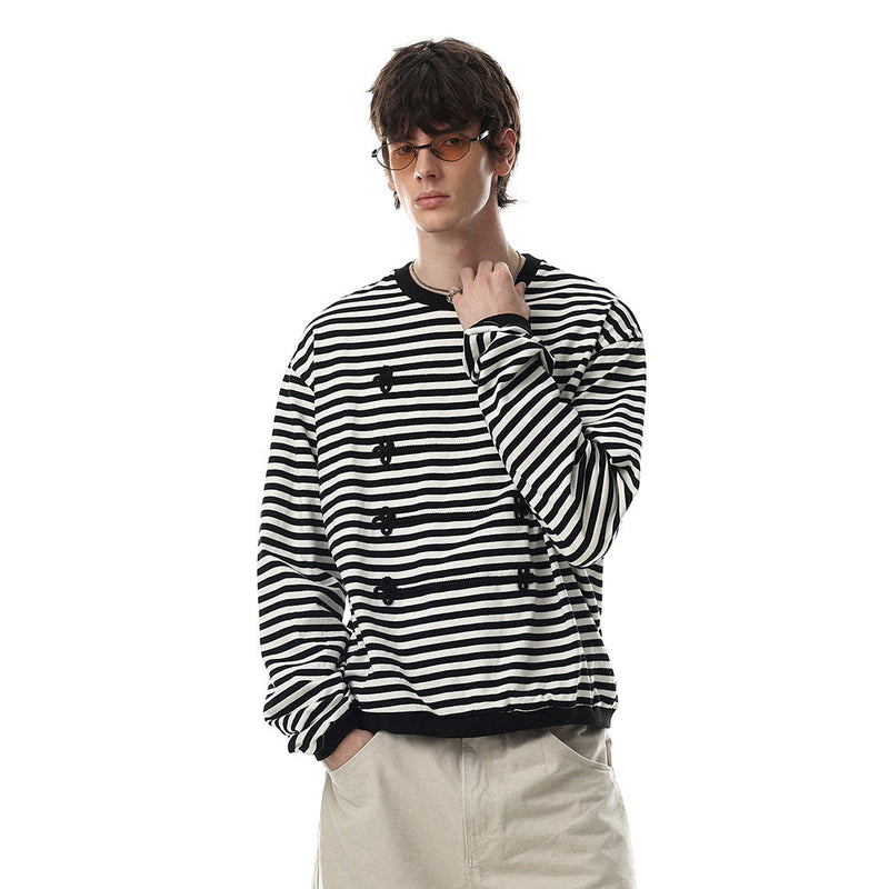 Model wearing black and white striped long sleeve shirt with contrast trim and floral knit front