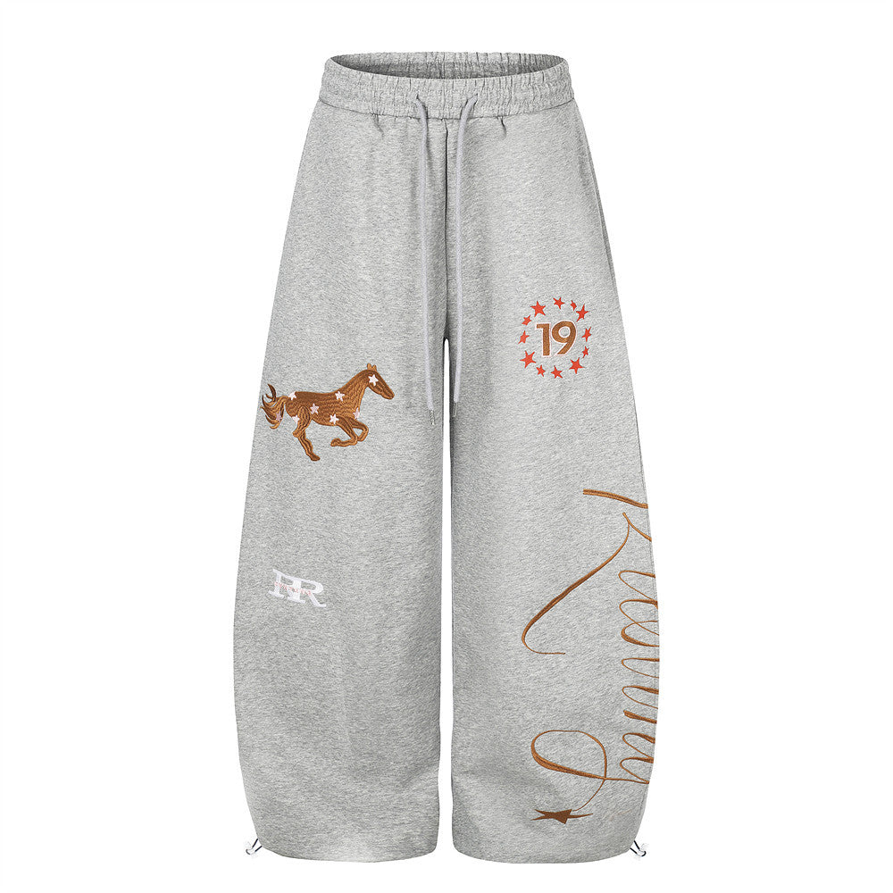Front view of gray wide-leg sweatpants with horse embroidery, star 19 graphic, and script print