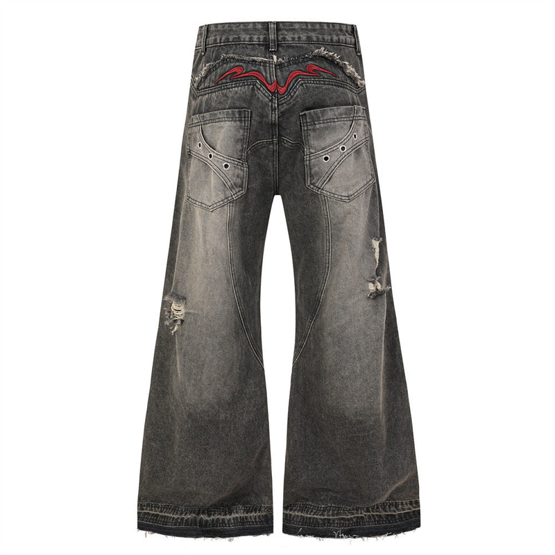 Back view of black wide leg jeans with faded wash, red embroidered yoke, and frayed hems