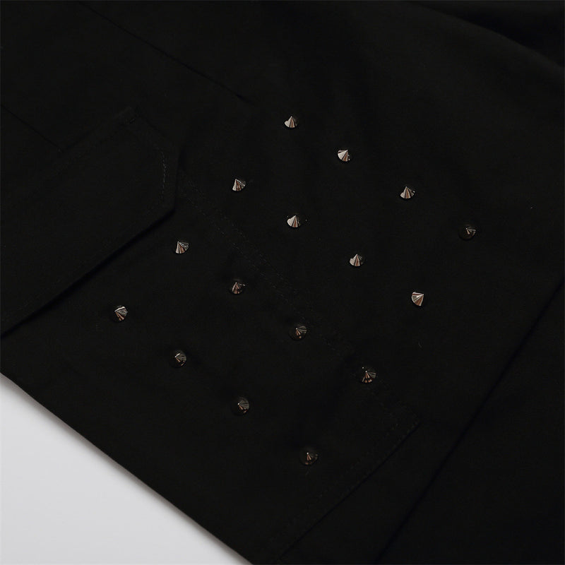 Close-up of black shorts front panel with small silver studs