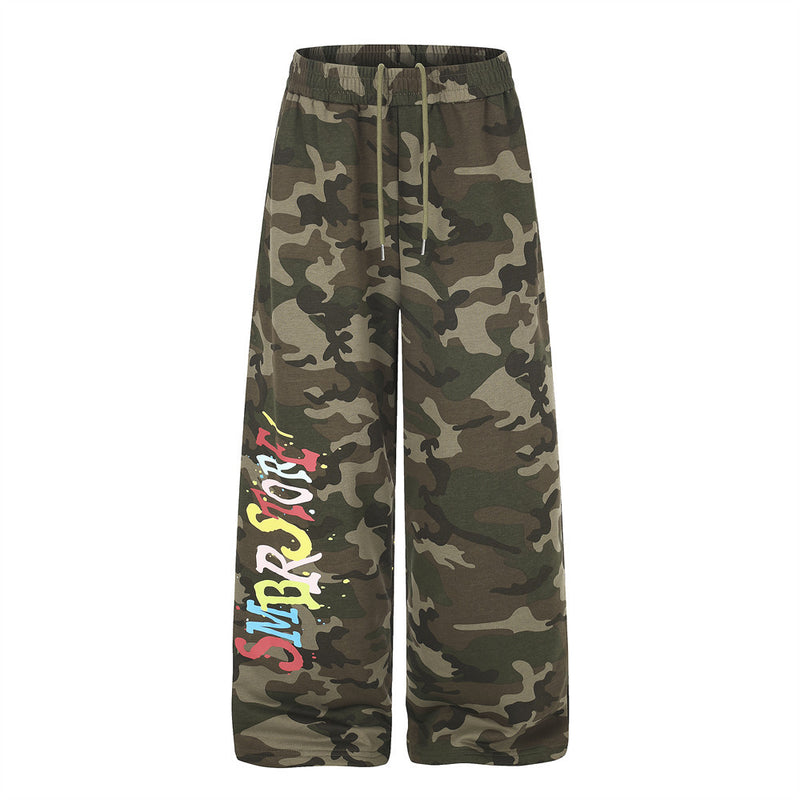 Pantalon de survêtement homme camouflage à jambes larges, avec imprimé graffiti multicolore et éclaboussures de peinture sur la jambe gauche