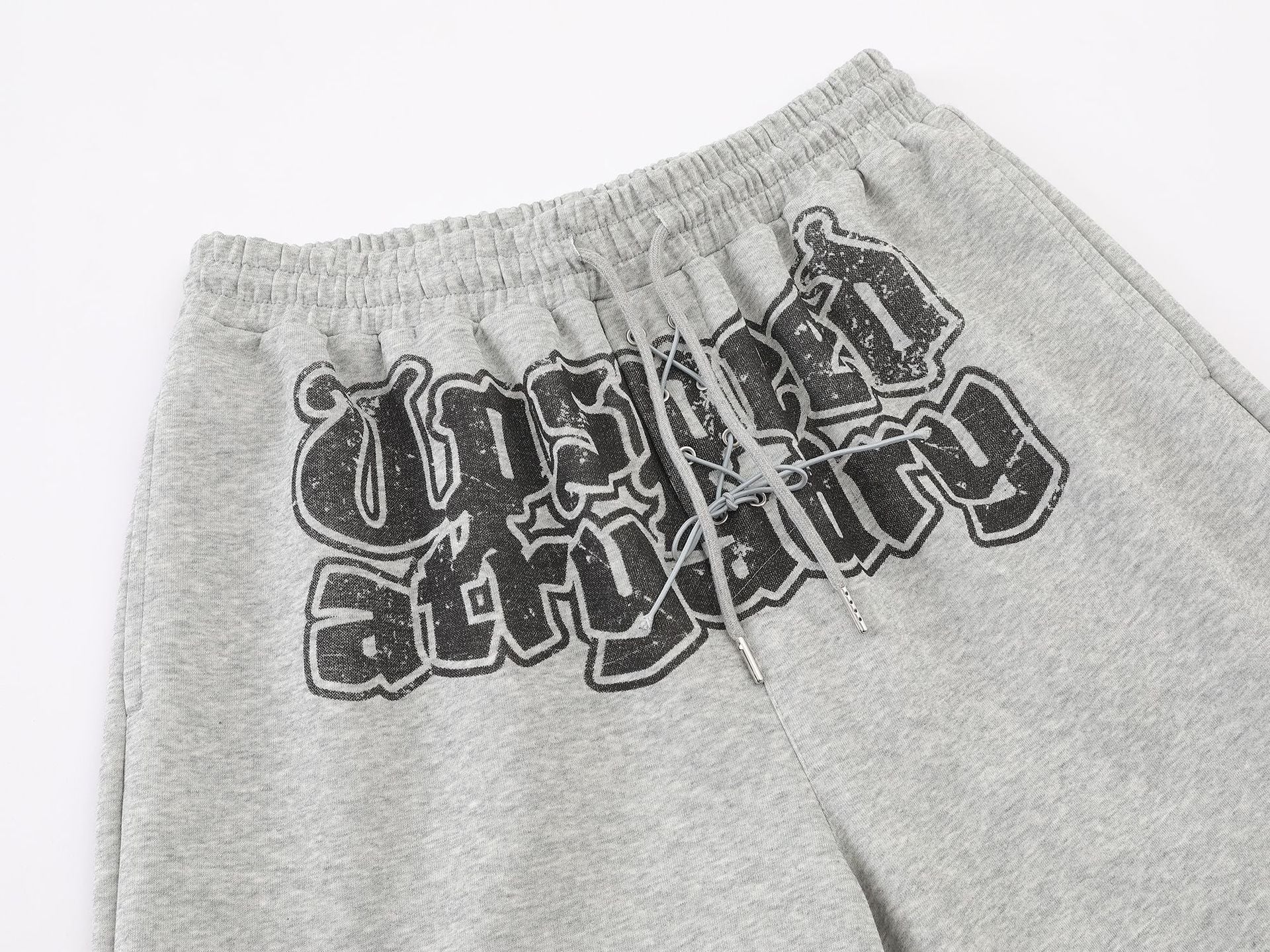 Pantalon de survêtement à jambes larges avec graphisme graffiti et ourlet orné de détails métalliques