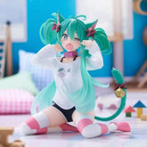 The 11cm PVC figure "Kneeling Cat-Ear Hatsune Miku" features the iconic green twin-tails, cat ears, and a white sweater. With striped pink and white socks, a pink bell collar, vibrant cushions, and playful toys on a pastel floor, it captures the essence of cute anime figures.