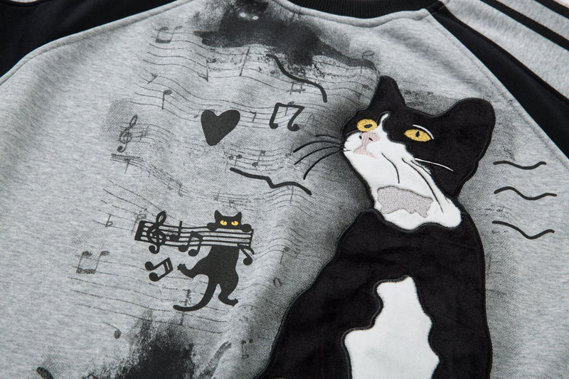 Sweat-shirt motif chat en smoking avec imprimé note de musique et manches raglan color block