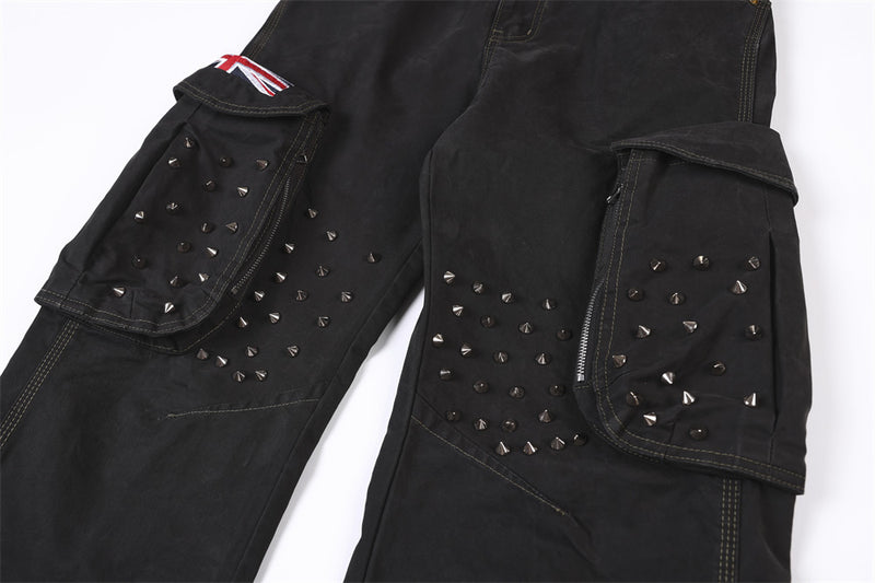 Close-up of studded cargo pockets on black pants with flap covers and zip details