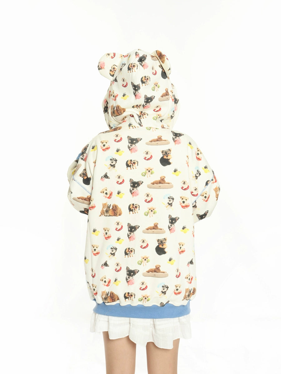 A child in a Seakoff MKCH Dog Print Hoodie featuring a bear-eared design is seen from behind. The hoodie, paired with a blue shirt and white skirt, makes for an ideal outfit for young fashion enthusiasts against a plain white backdrop.