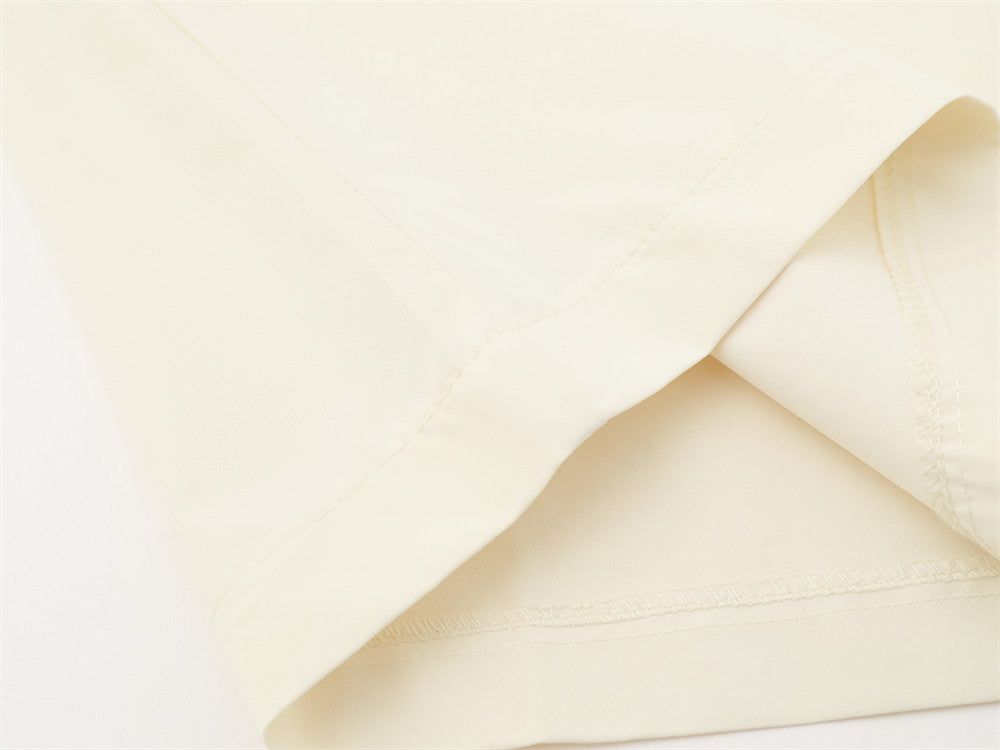 Close-up of cream shirt hem with neat stitched edge