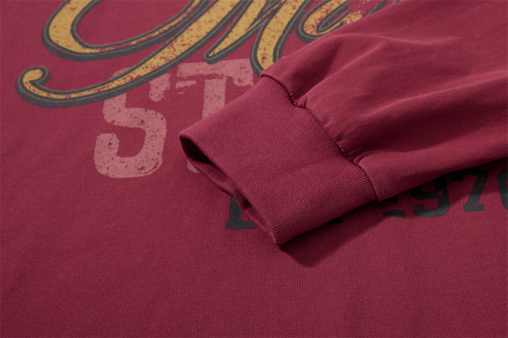 Close-up of burgundy sleeve cuff and front print on long sleeve shirt