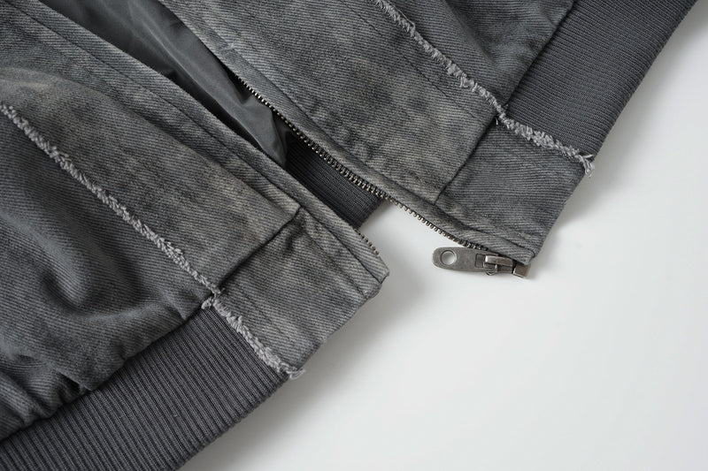 Veste bomber en jean délavé déconstruite à empiècement croisé et coutures effilochées